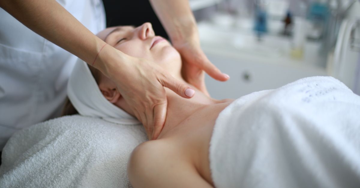 Woman receiving a soothing neck massage at a spa, promoting relaxation and wellness.