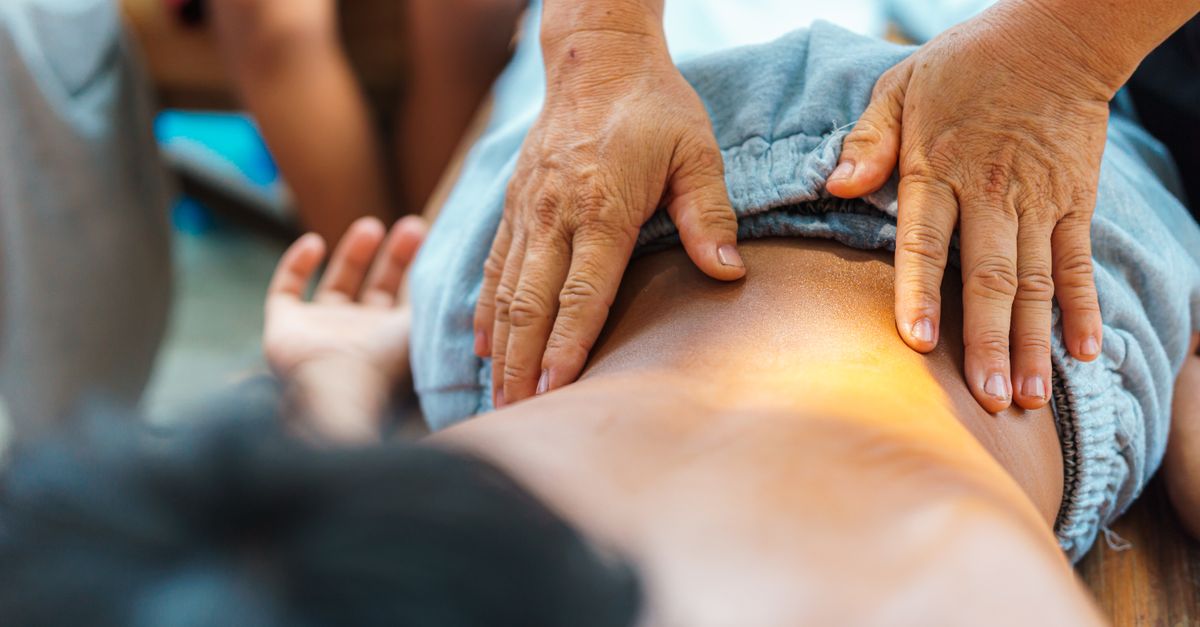 A soothing back massage performed by a therapist outdoors, focusing on relaxation and well-being.