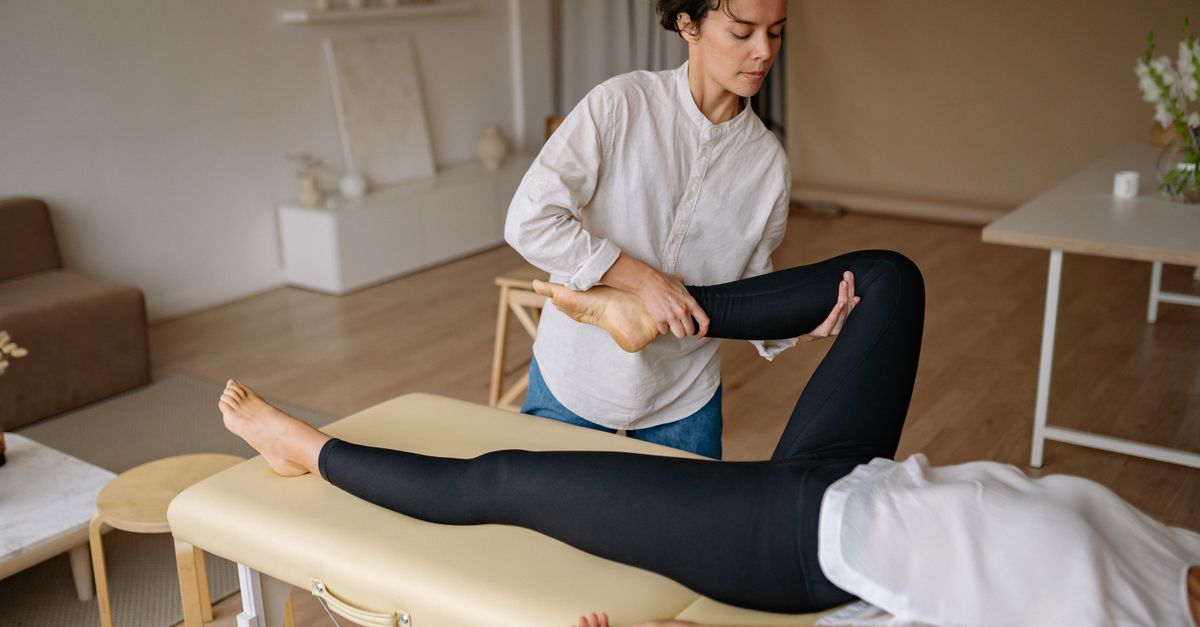 A massage therapist provides a rejuvenating leg treatment in a calming spa environment.