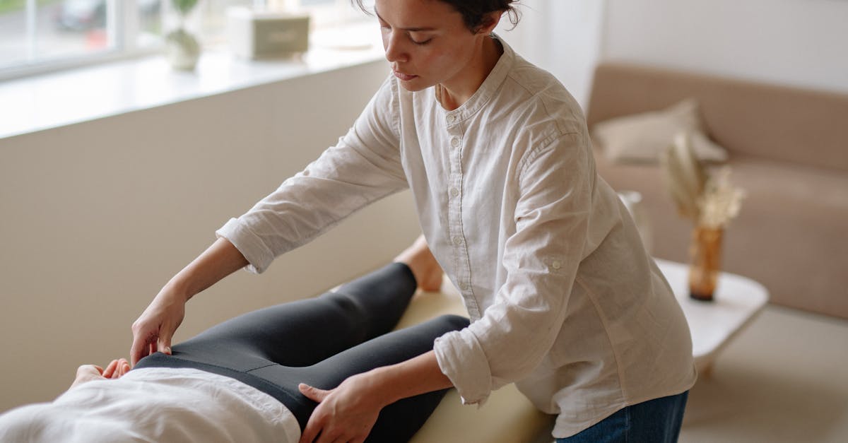 A massage therapist provides care to a lying patient in a tranquil indoor setting.