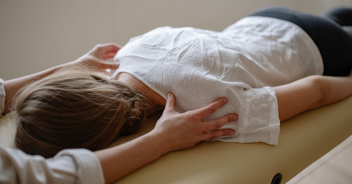 A woman receiving a calming massage therapy session on a comfortable table.