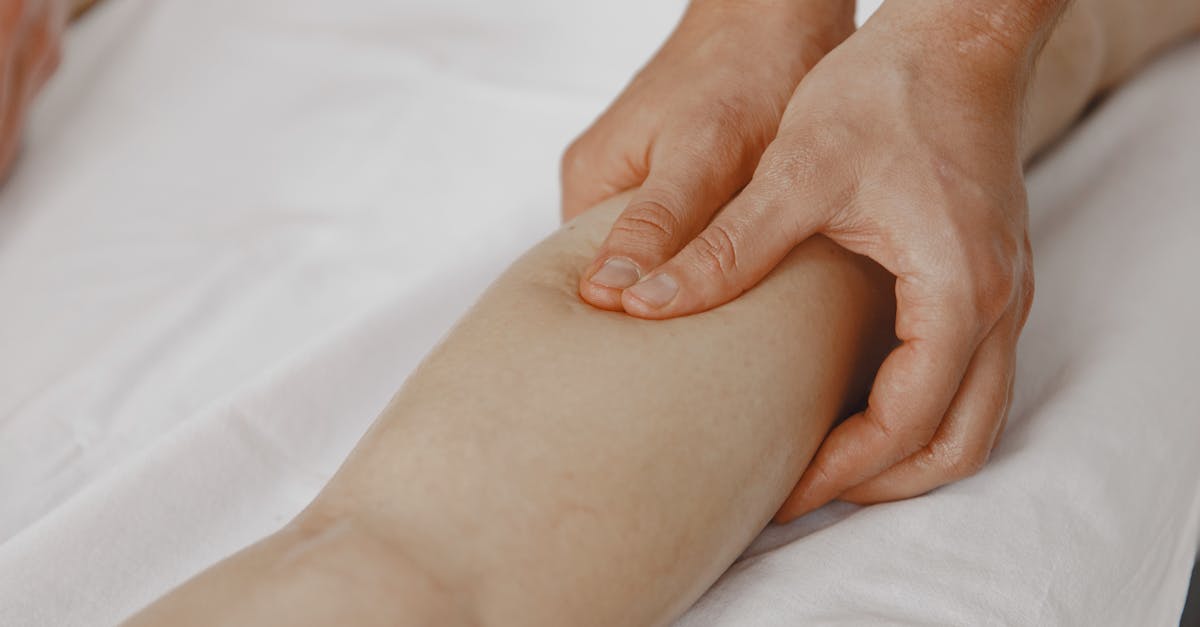 Close-up image of a massage therapist applying pressure on a client's leg for muscle relaxation.