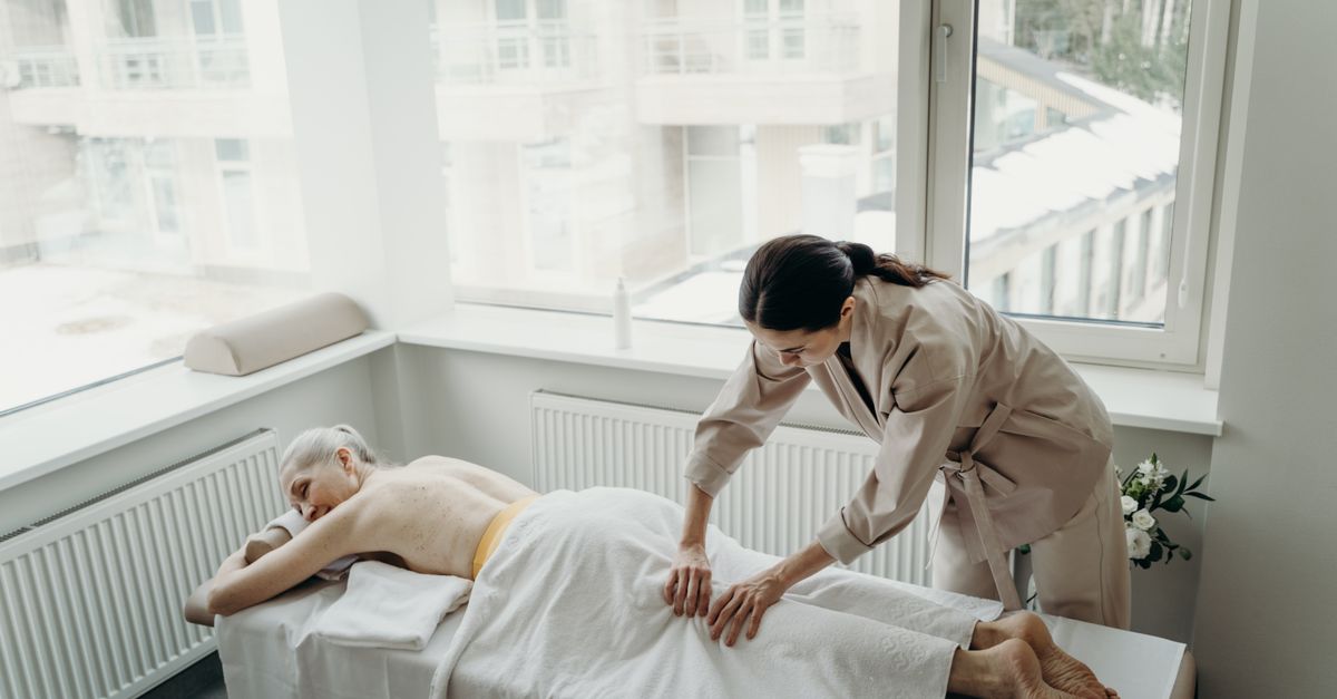 Senior woman enjoying a therapeutic massage in a peaceful indoor spa setting.