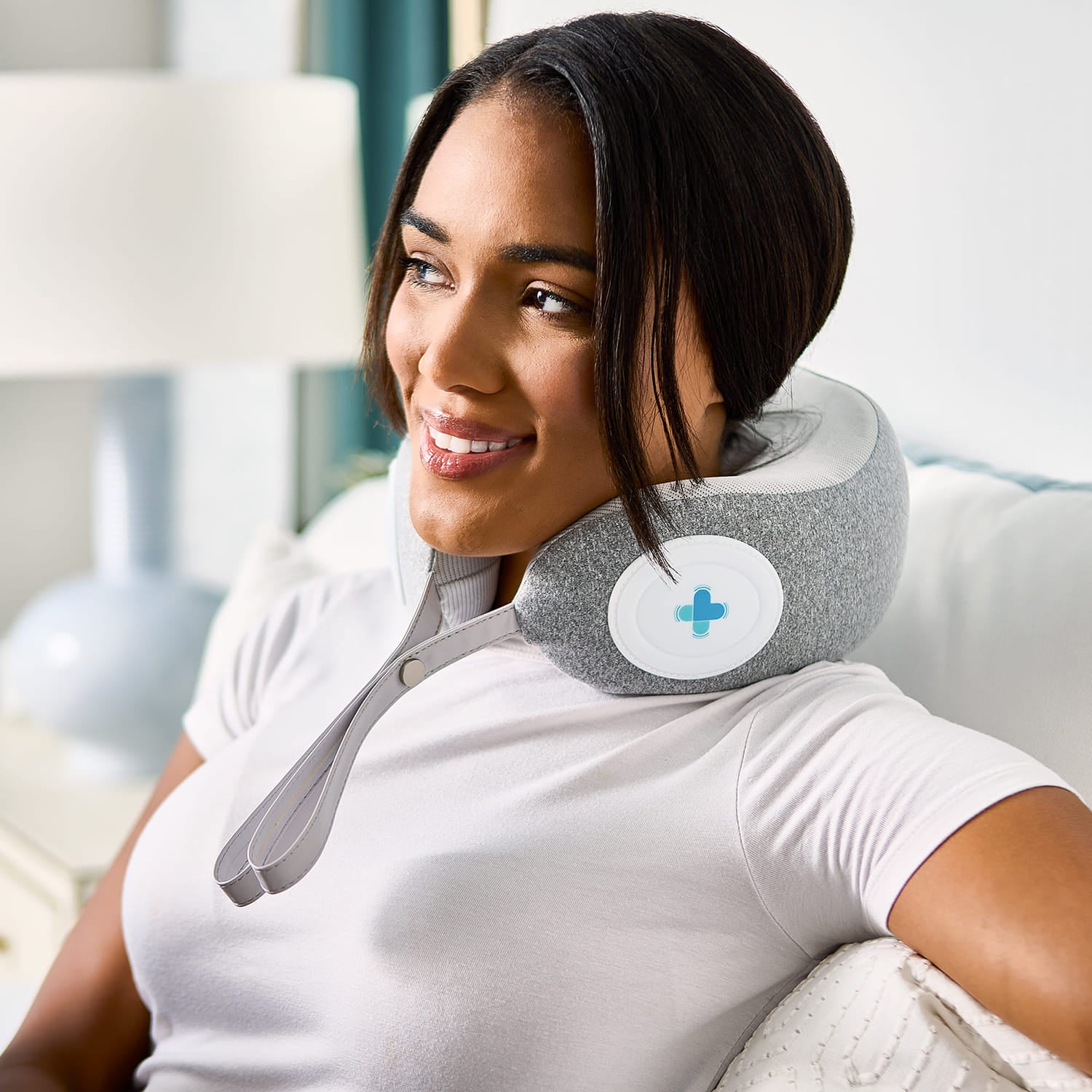 Woman using a neck massager in a modern living room
