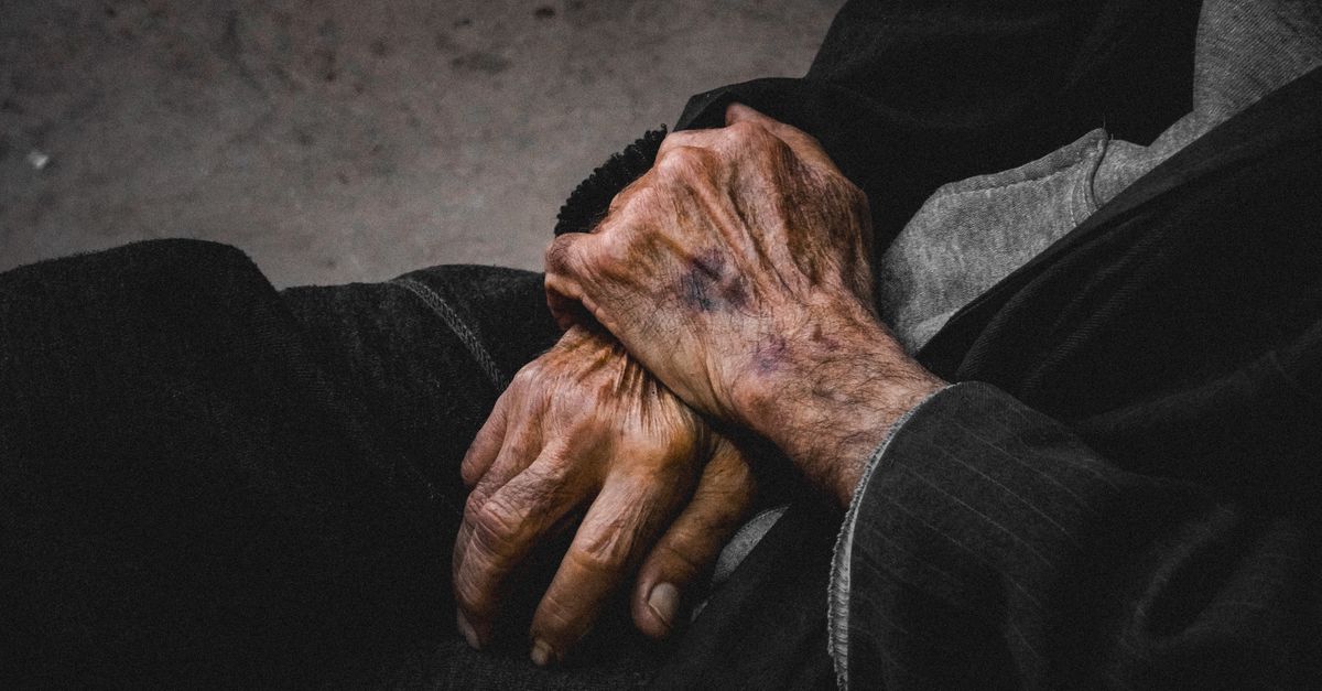 A close-up of elderly hands clasped together.