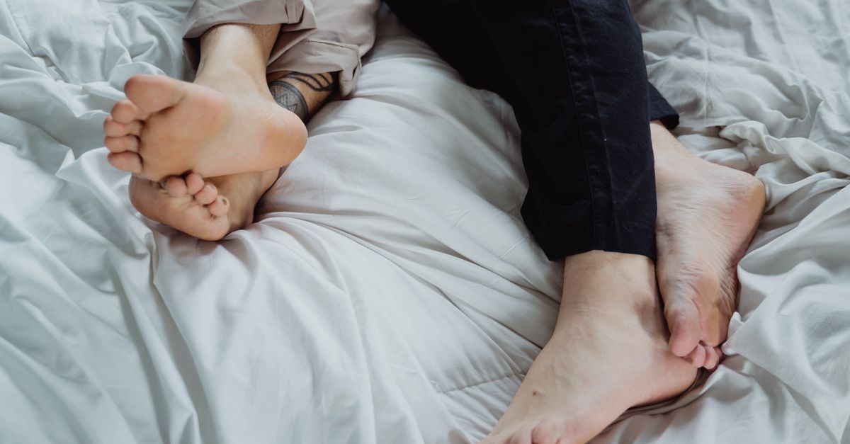 Relaxing scene with bare feet resting on a bed, conveying comfort and peacefulness.