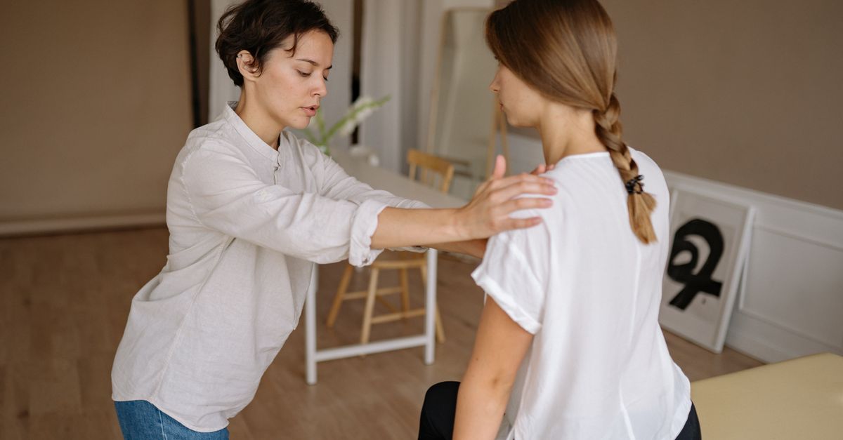 A massage therapist works with a client in a calm indoor setting.