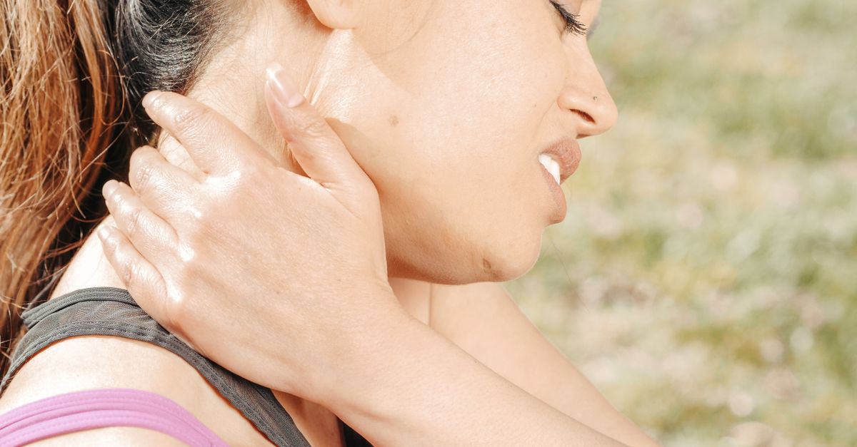 Close-up of a woman experiencing neck pain.