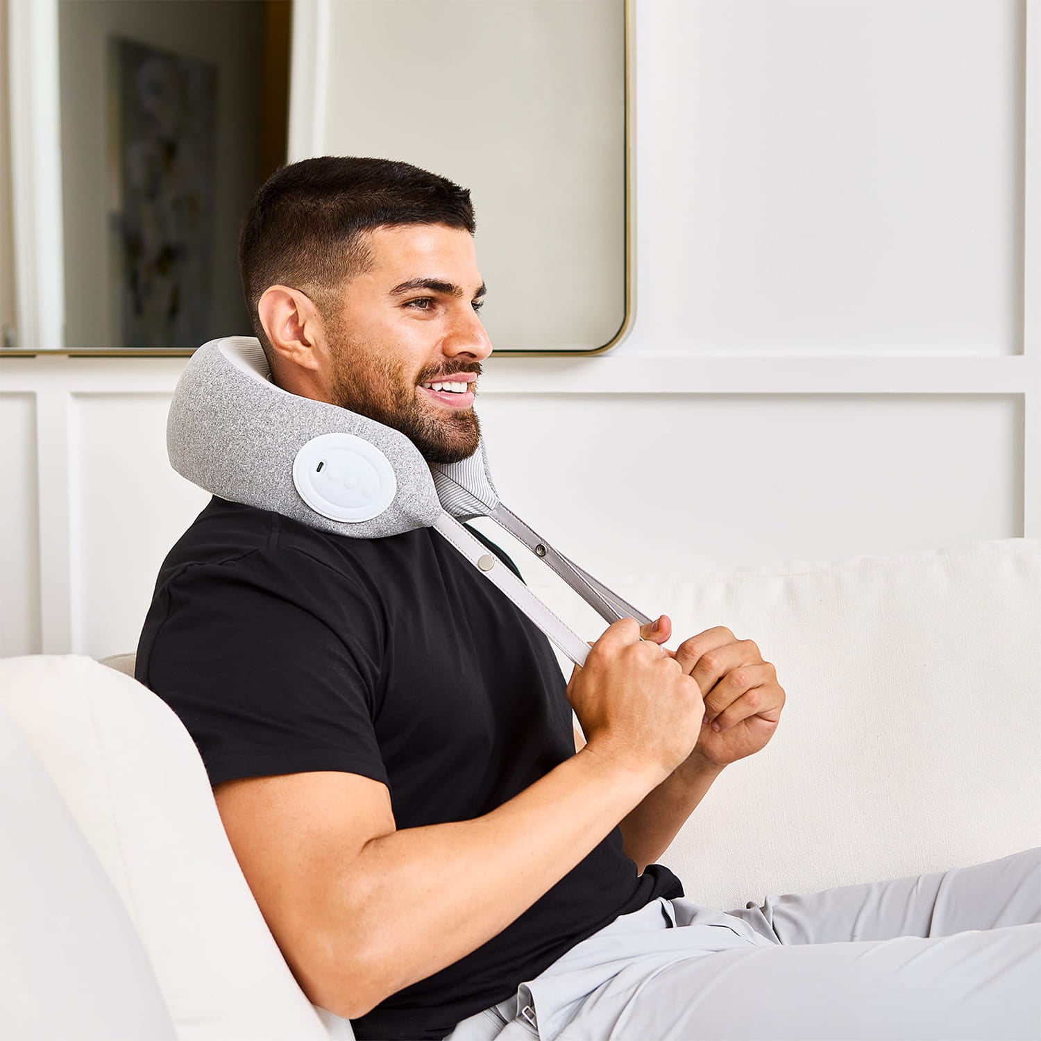 Man using a neck massager in a home setting